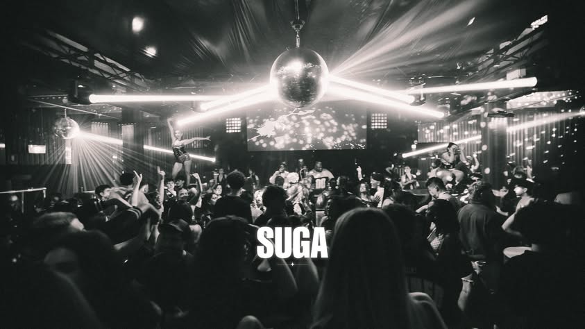 The SUGA crowd and DJ booth under bright stage lights
